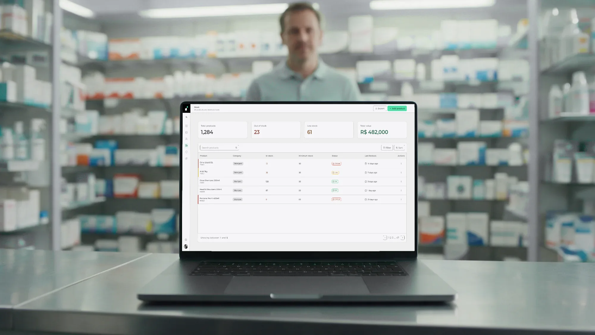 A store manager in a pharmacy stockroom with Instivo's stock overview open on a laptop