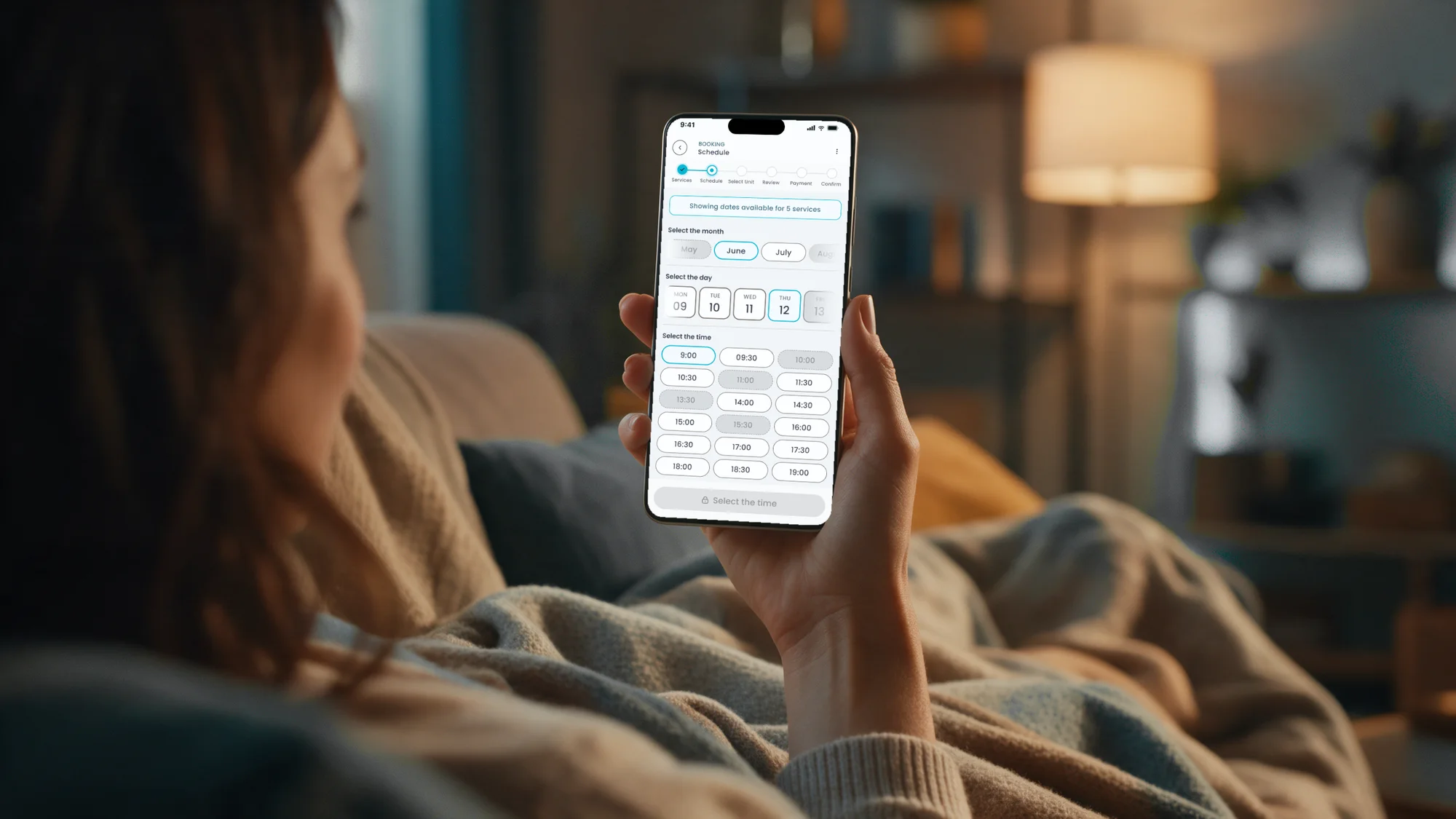 A patient on her sofa booking exams on the MedMe app